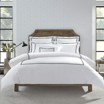 Crisp white bedsheet neatly tucked on a hotel bed