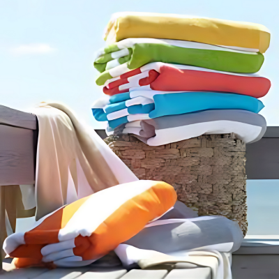 Colorful pool towels stacked by a lounger